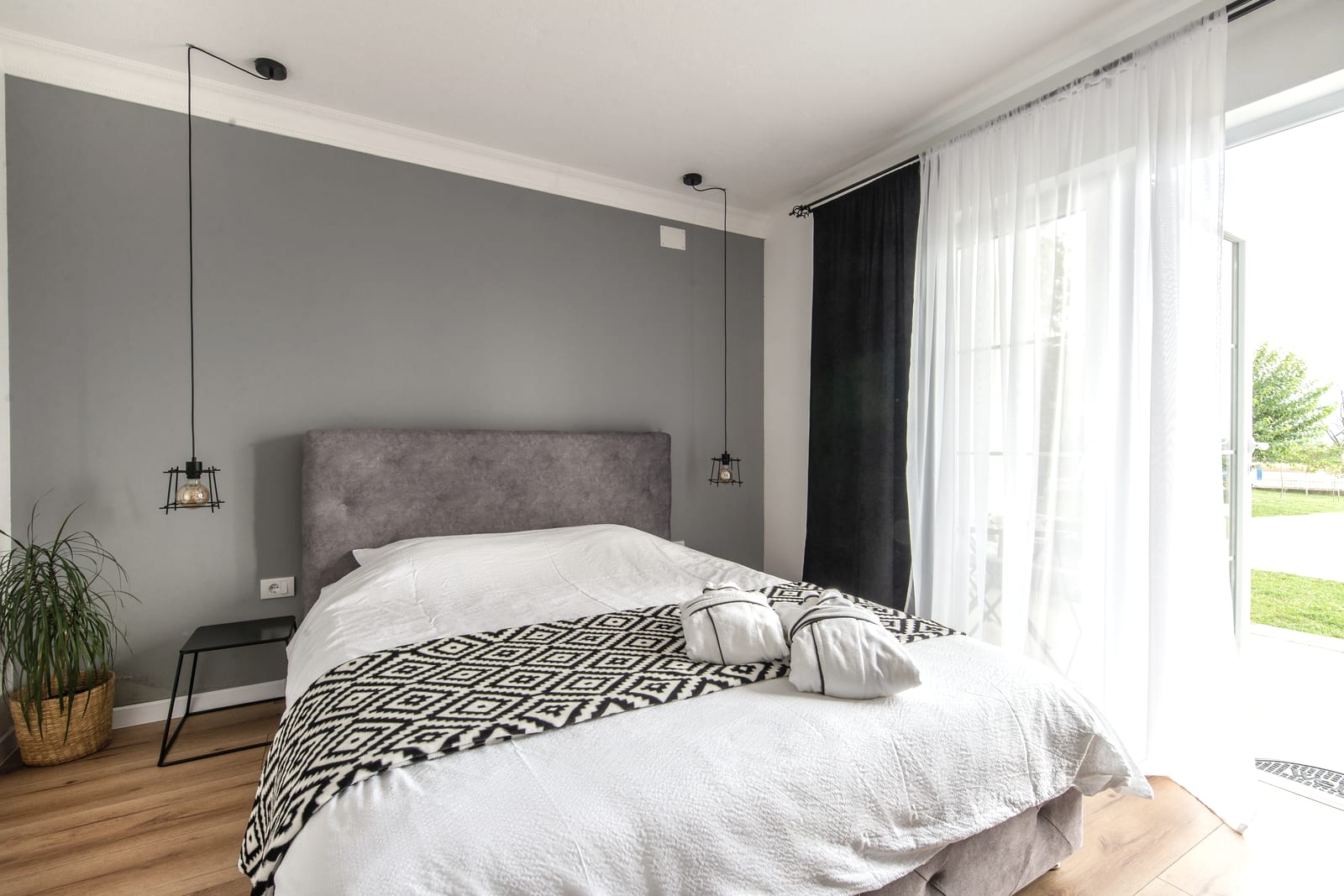 A made bed with white linen in morning light