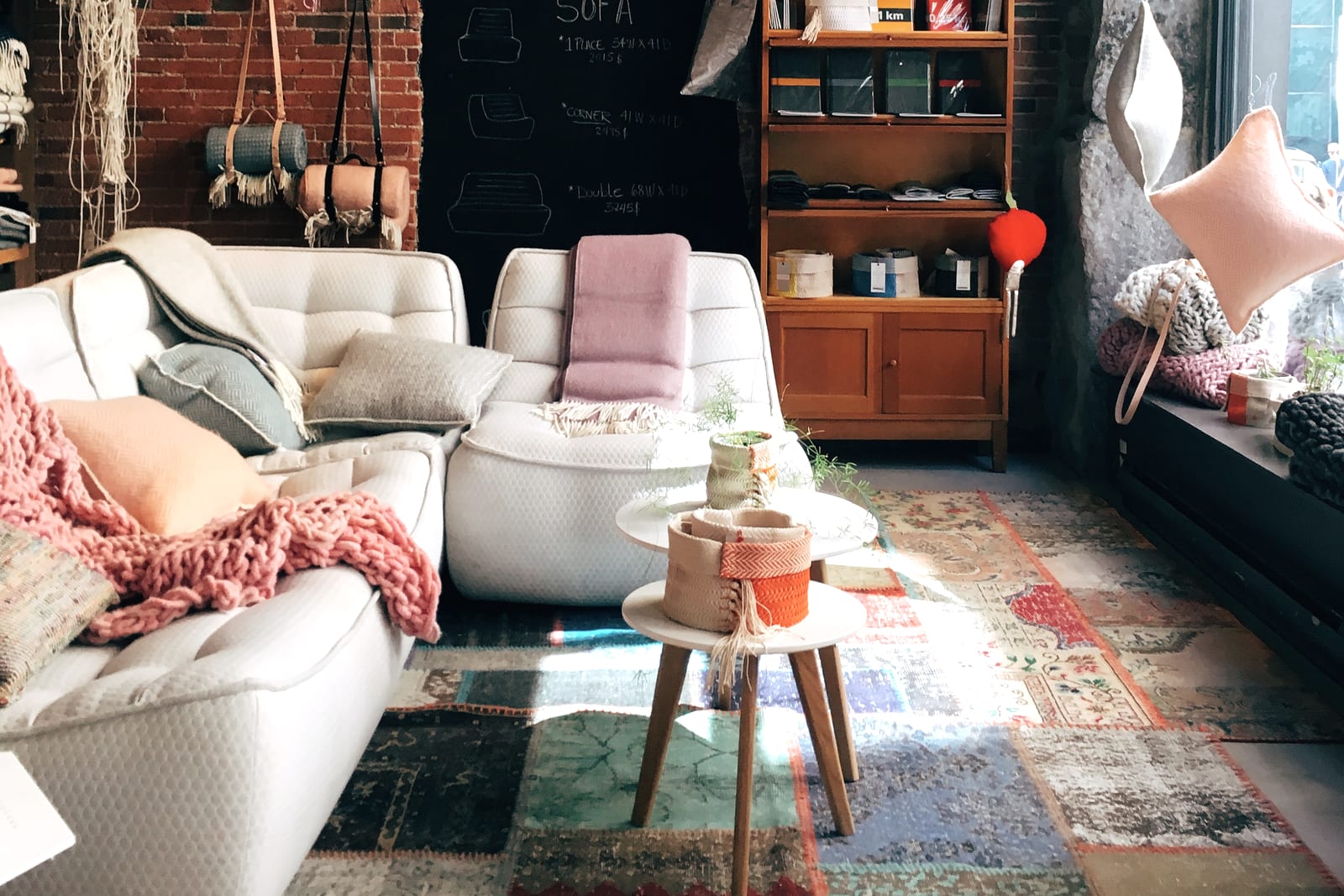 A furnished living room with cushions, a rug and window light